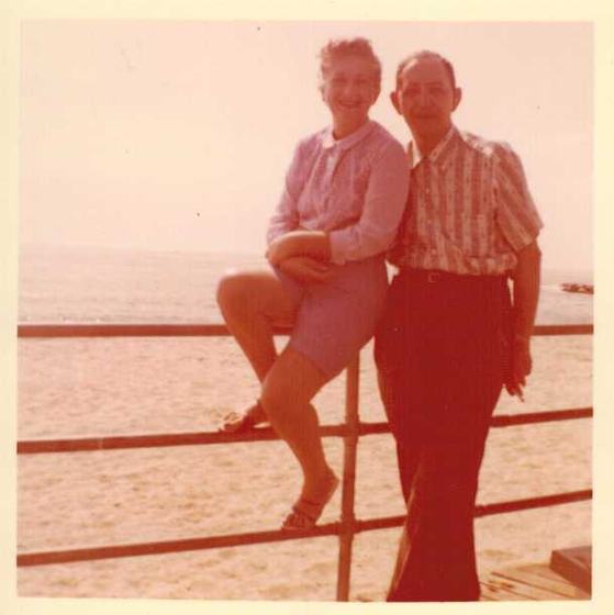 Harold and Mae at a boardwalk railing above the beach.