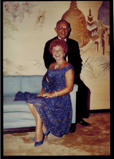 Harold and Mae on a sofa in front of a painted mural.