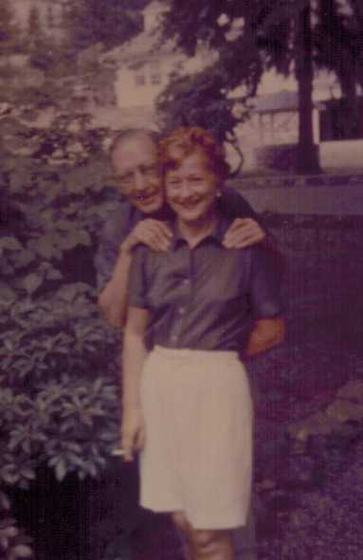 Harold and Mae in a garden (faded color print). Mae is smoking.
