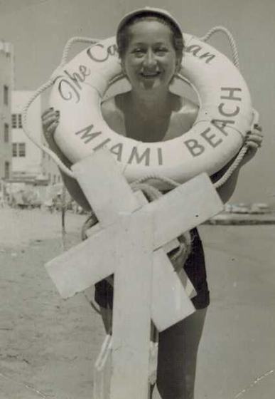 Mae holding a life ring marked The Caribbean, Miami Beach.