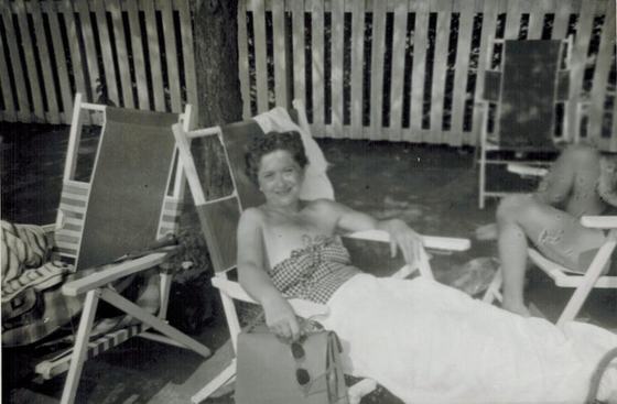 Mae on a lounge chair in a backyard.