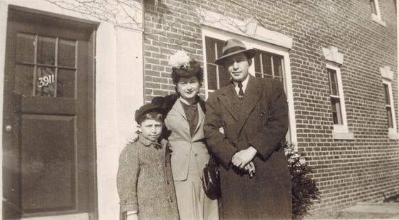 Mae, Warren and Harold in front of a door numbered 3911.