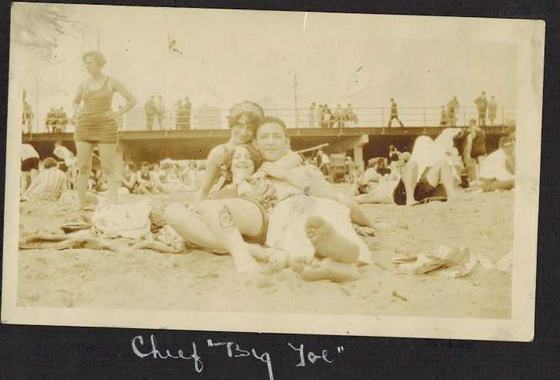 Harold and Mae lying together on a crowded beach.