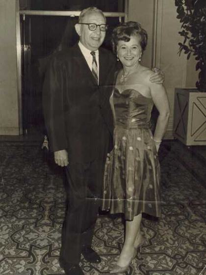 Harold and Mae at a formal event, he in a dark suit, she in a strapless polka-dot dress.