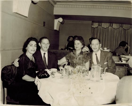 Harold and Mae at a restaurant table with another couple. Harold is at the right and Mae is beside him.