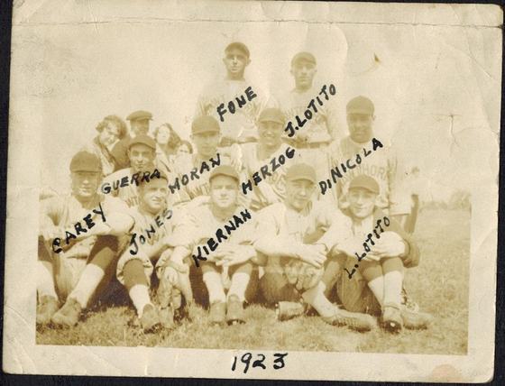 A baseball team in uniform, posed in a field. Written in ink on the photo: Carey, Guerra, Jones, Moran, Kiernan, Fone, Herzog, J. Lotito, L. Lotito and DiNicola. The album page says "Baseball in its prime."