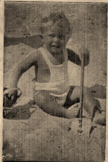 Harold as a small child, smiling in the sand with a stick. A tintype (an early metal-plate photograph) in its original paper mount.