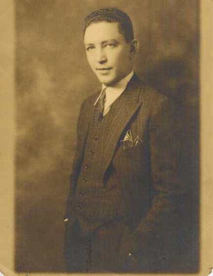 Harold as a young man in a studio portrait: a pinstriped three-piece suit, a patterned tie and a folded handkerchief, one hand in his pocket.